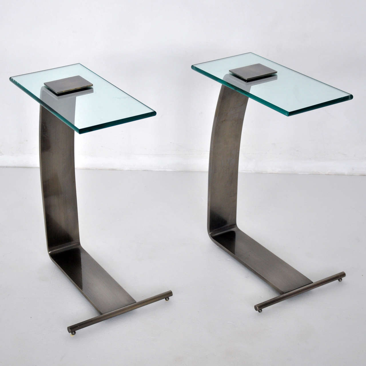 Pair of Design Institute America side tables. Gunmetal frames with cantilever glass.