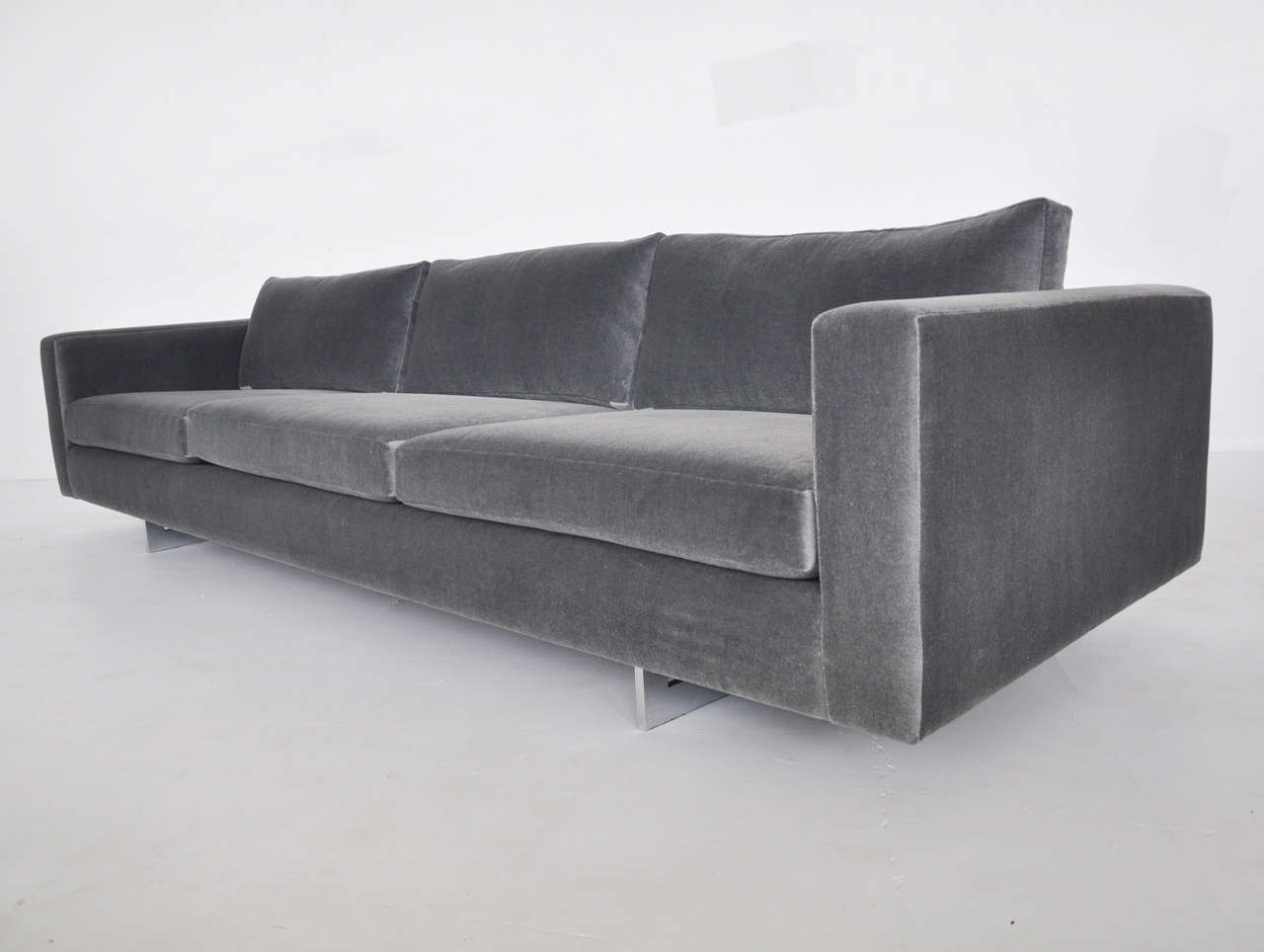 9ft sofa by Jens Risom. Newly upholstered in charcoal mohair. Polished chrome sled bases.