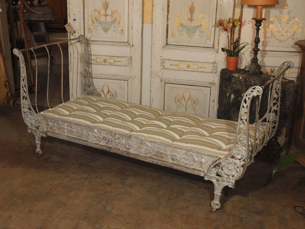 Iron day bed made of cast and wrought iron, with remains of old silver and white paint.   (Mattress not included.)