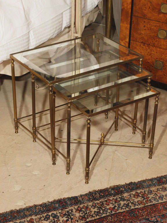 Brass nest of tables with mirrored, framed glass tops and fluted, Louis XVI sytle legs.