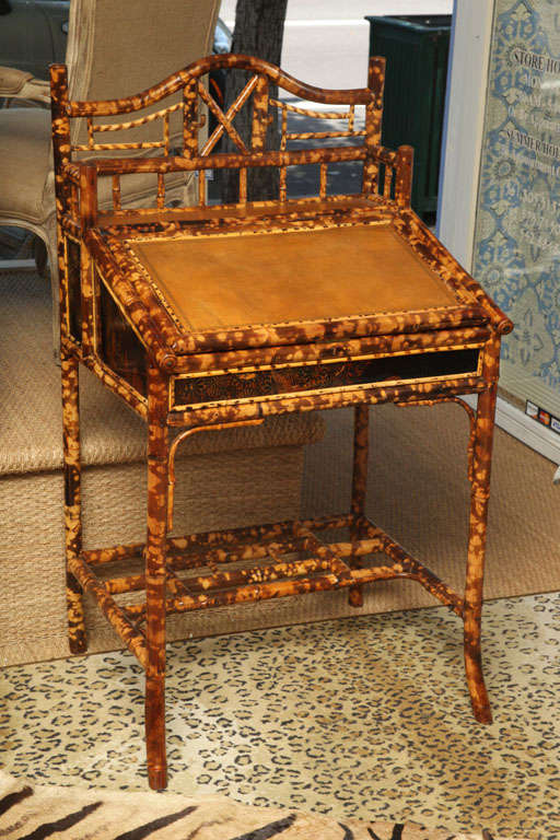 Very fine English bamboo lift top writing desk with gold tooled leather writing surface,upper gallery and lower storage shelf.