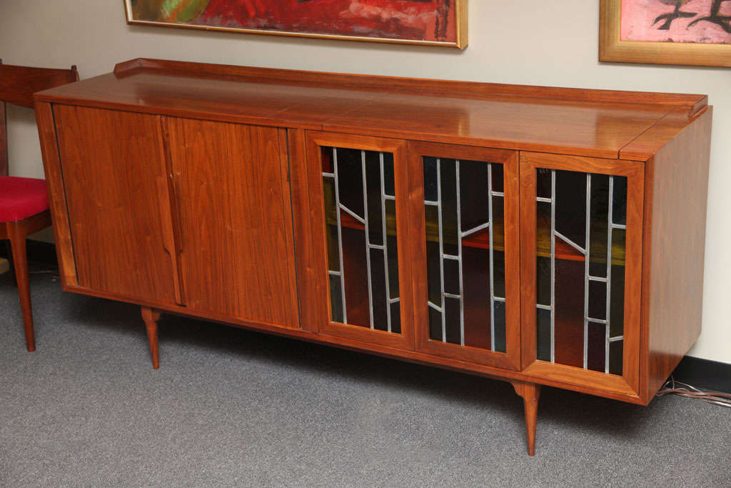 ...SOLD MAY 2011...Absolutely beautiful teak credenza or buffet, originally a custom order from 1958 with sliding tambour doors opening to an adjustable shelf and three matching stained glass doors, two bi-fold, opening to storage.  Top door opens