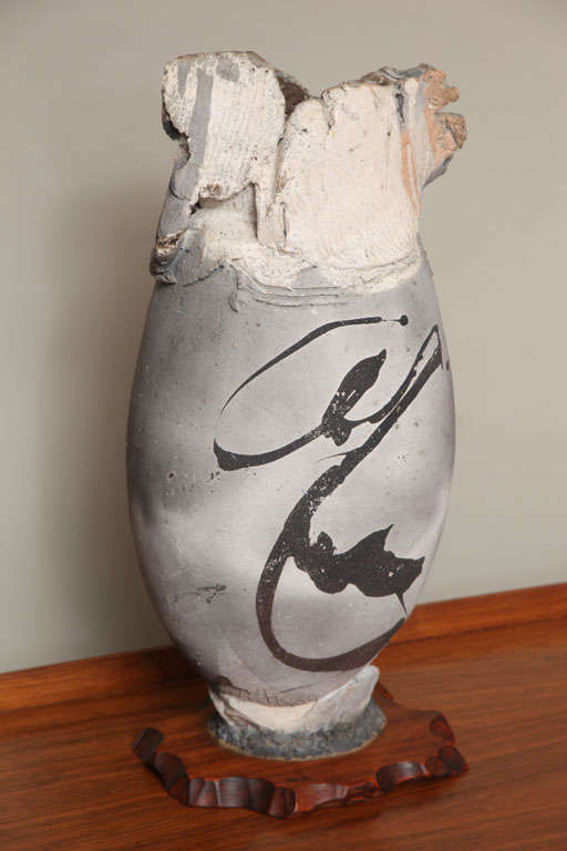 REDUCED FROM $9,500.
Fine and monumental Paul Soldner raku pedestal vase with fumed greys, beige and pink, stylized calligraphy and raw energy. Chop mark signed. Great scale at 19