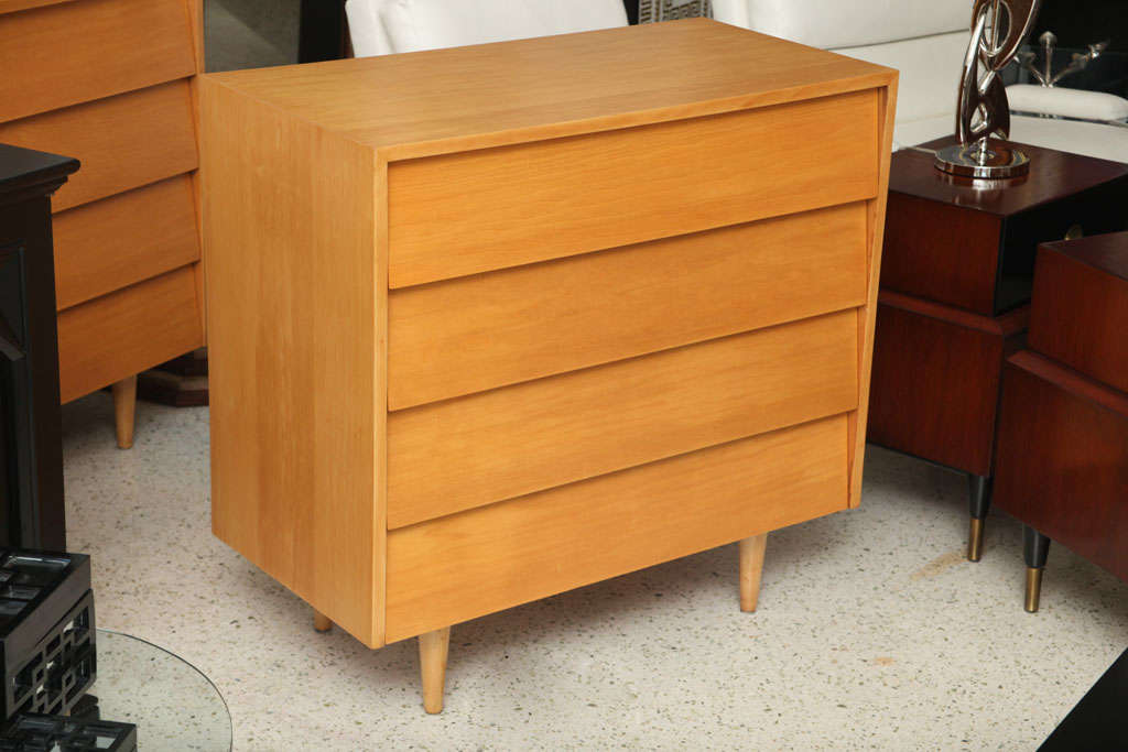 A pair of Maple dressers by Knoll, featuring slant front drawers, set on tapered feet.