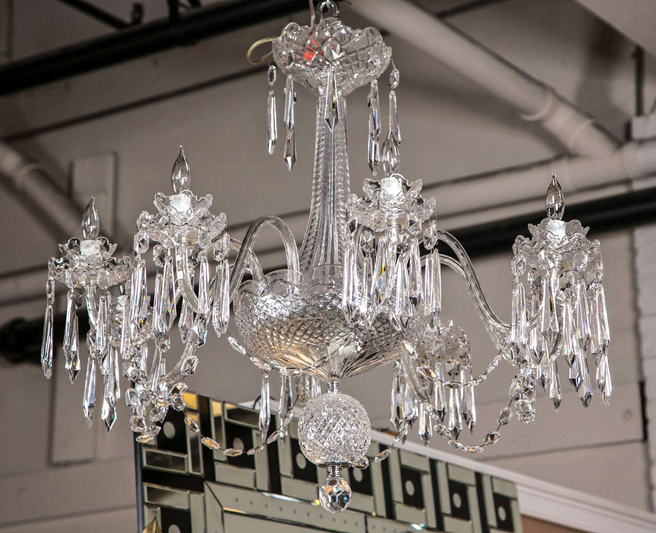 A spectacular Waterford crystal chandelier. This full crystal chandelier having a heavy cut overall structure with a central pole leading to a large center dish and double ball base. All-over swag and prism form decorated. Each piece with the