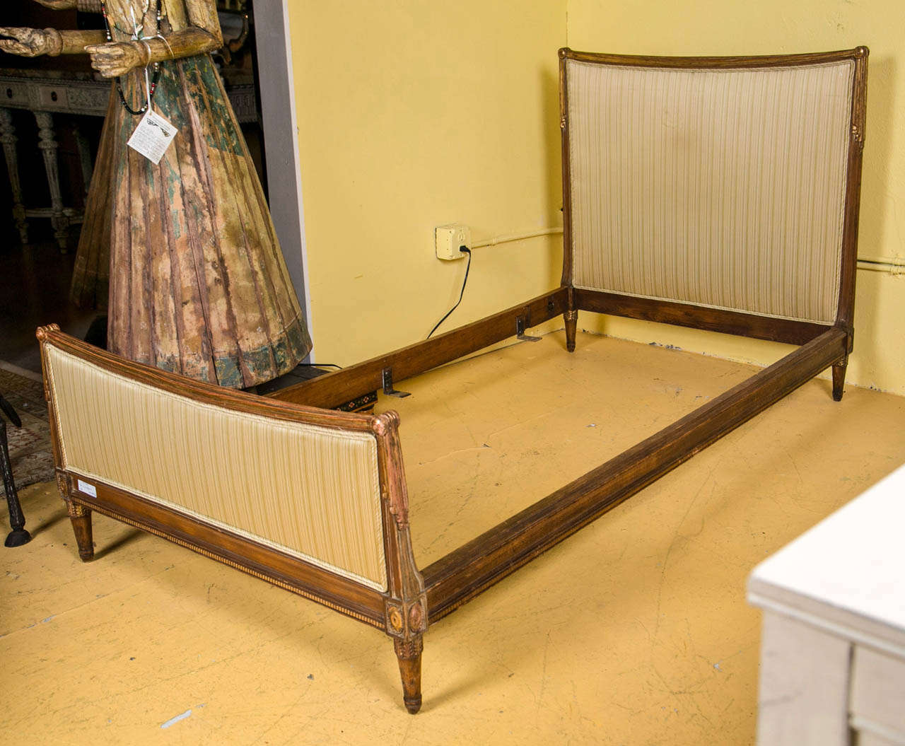 A finely carved pair of gold leaf twin beds.  Each Louis XVI style leg supporting a finely gilt and nicely upholstered wooden bed frame terminating in tastle and drapery form curved tops.  Wonderful example of the hollywood regency era. Each with a