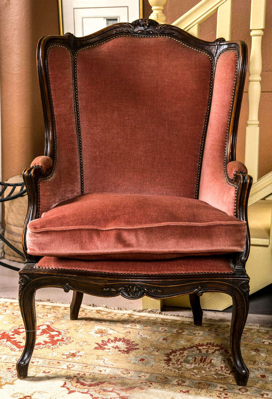 A fine custom quality pair of Louis XV Style Wing Back Arm Chairs. Both standing on Cabriole legs and curved wooden frames. The velour upholstery finished in bass tacks. Carved with rosettes and leaf design.