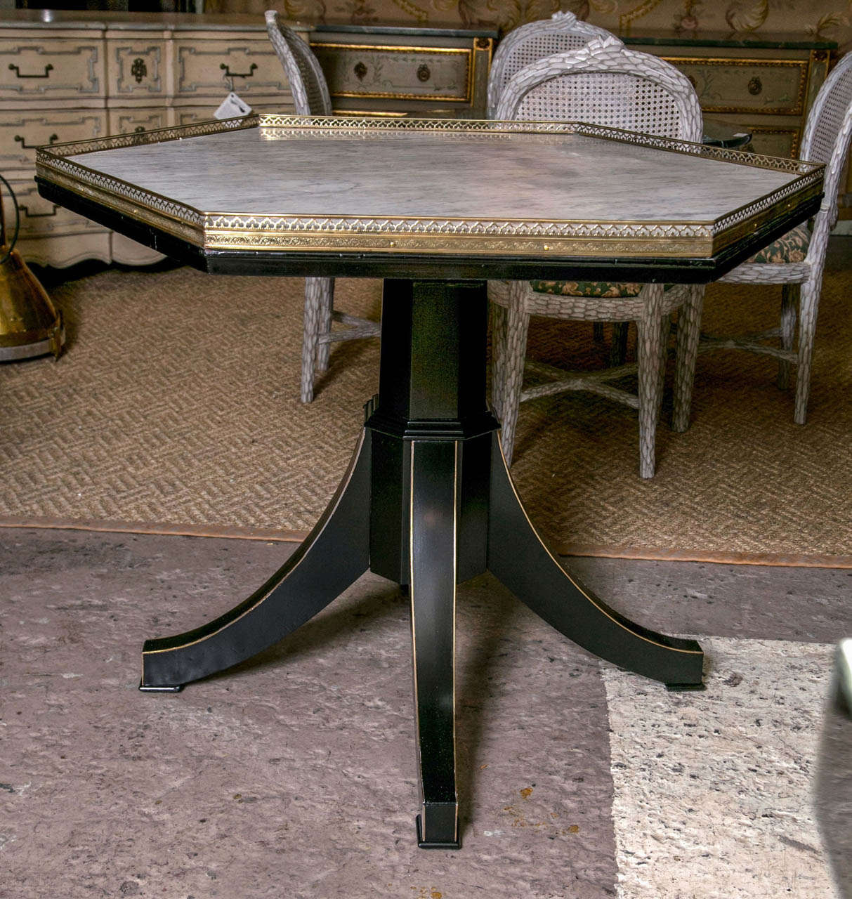 A fine Galleried marble-top centre table by Jansen. The brass inlaid line quad curved legs leading to a single pedestal base supporting a six sided bronze pierced top framing a white Carrara marble-top.

This piece is accompanied by a letter of