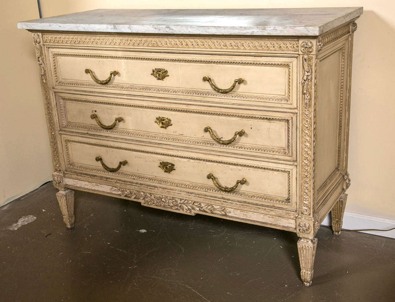 A very fine chest of drawers, commode, by Maison Jansen. Stamped and Made in France. The thick white marble top over a three drawer chest with finely carved sides, drawer frames and fronts in the Louis XVI taste. Heavy bronze finely cast pulls and