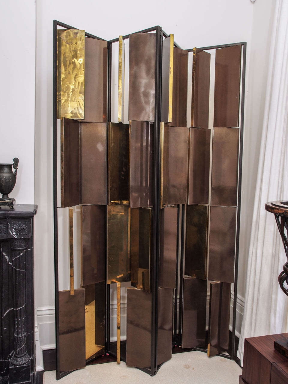 Chic and impressive fixed-panel screen attributed to William Sofield for Gucci; the frame in black painted iron; the adjustable inset panels finished in brass at one side, taupe lacquer at the reverse