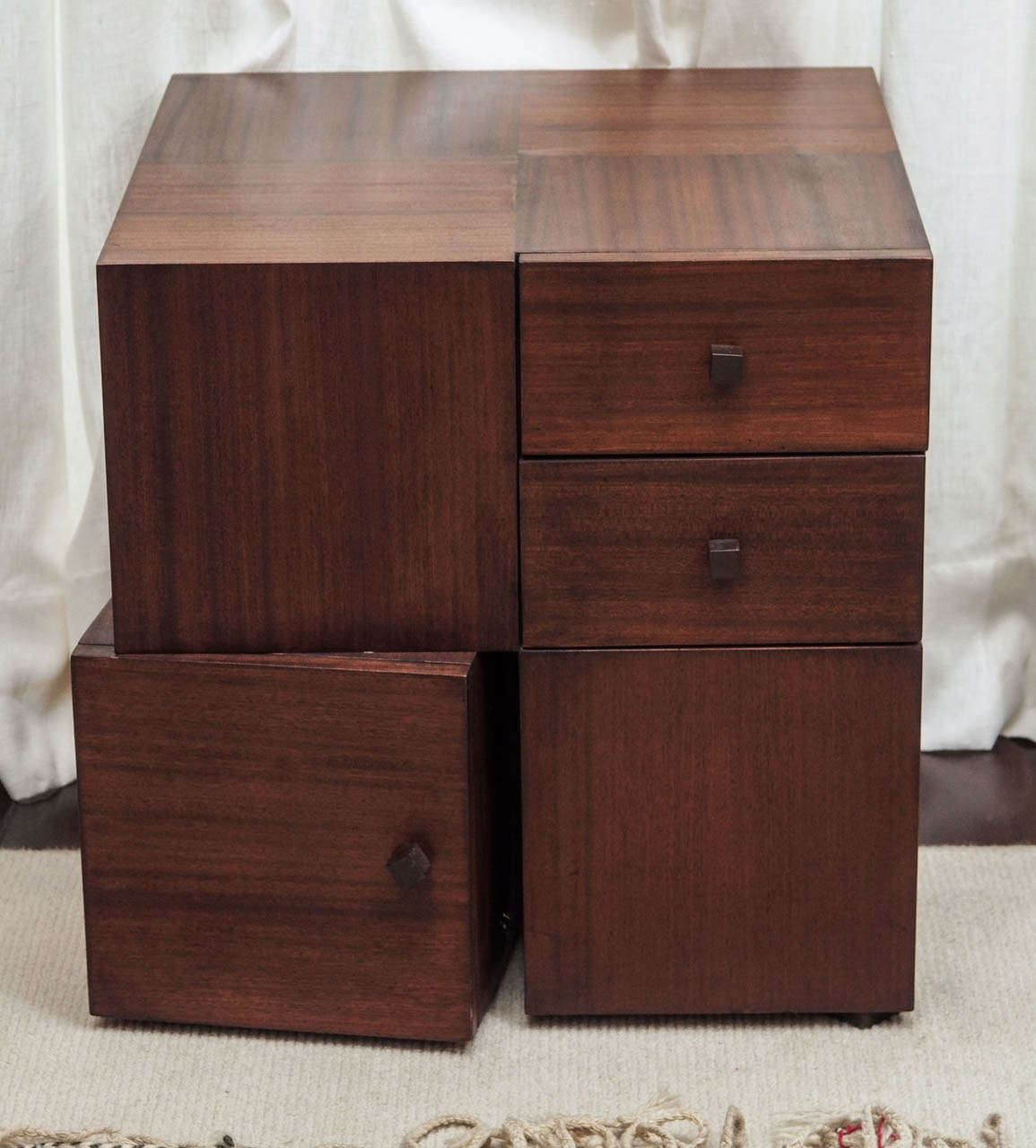 Two storage tables in hardwoods with mahogany veneers by Antoine Proulx; each with two drawers and one cabinet; the lower cabinet is fixed at an outward cant and does not pivot; bronze pulls