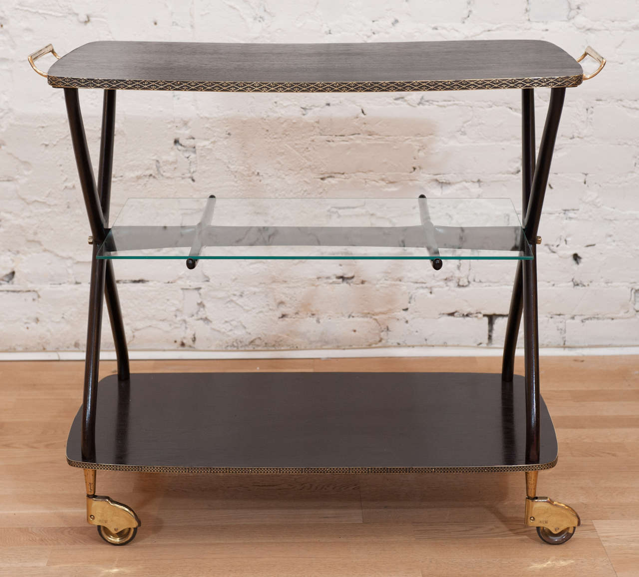 This swish and swank wood serving cart with brass handles has been restored to its early glory....refinished, polished with
new lower level glass shelf this Italian bar cart is ready to impress.