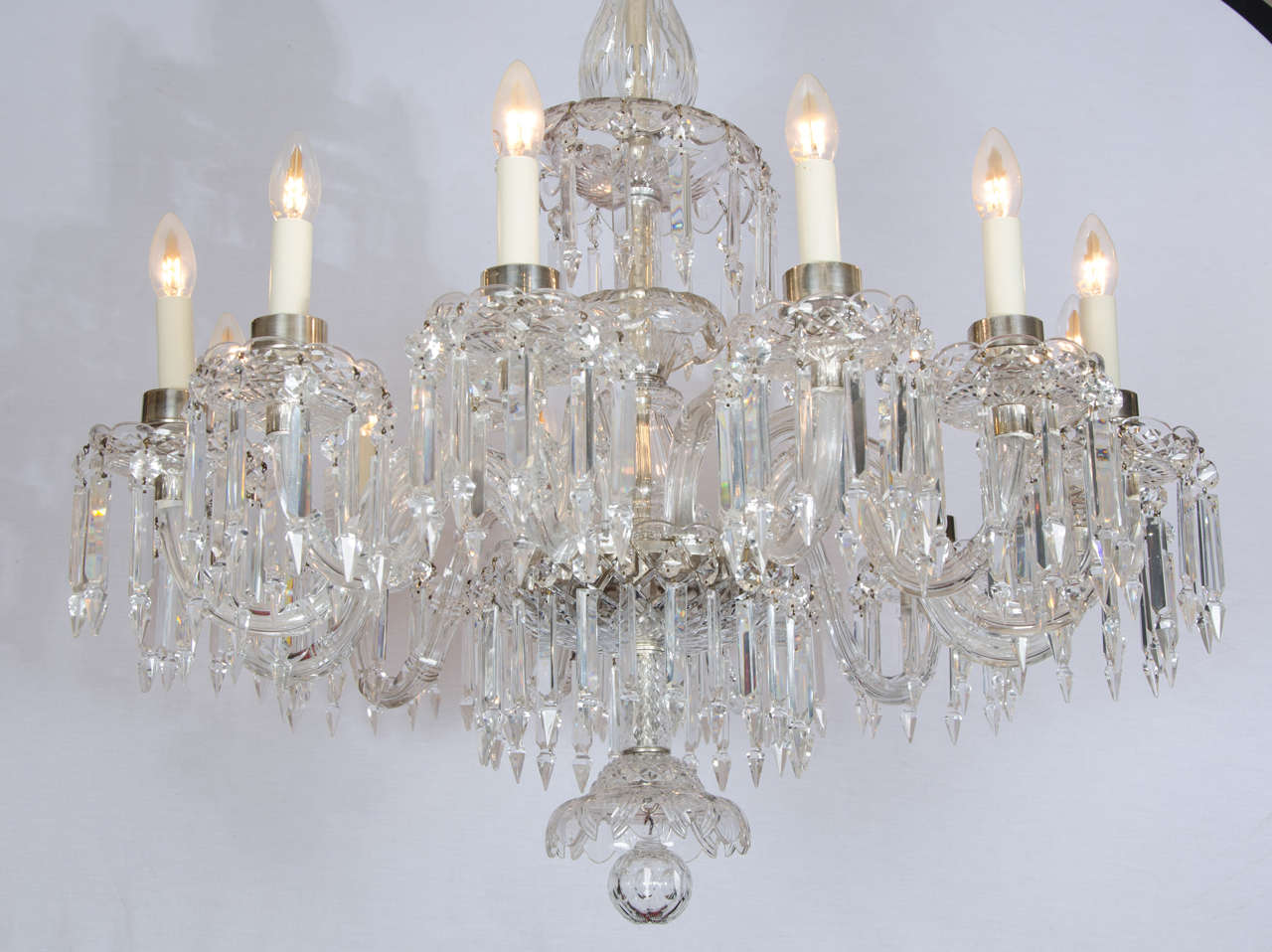 This elegant French crystal and glass chandelier has a single tier of 12 branches, arranged closely together for a full and lavish body of light. The crystal arms are supported in an ornate central column and showcase 12 candle shaped light fittings