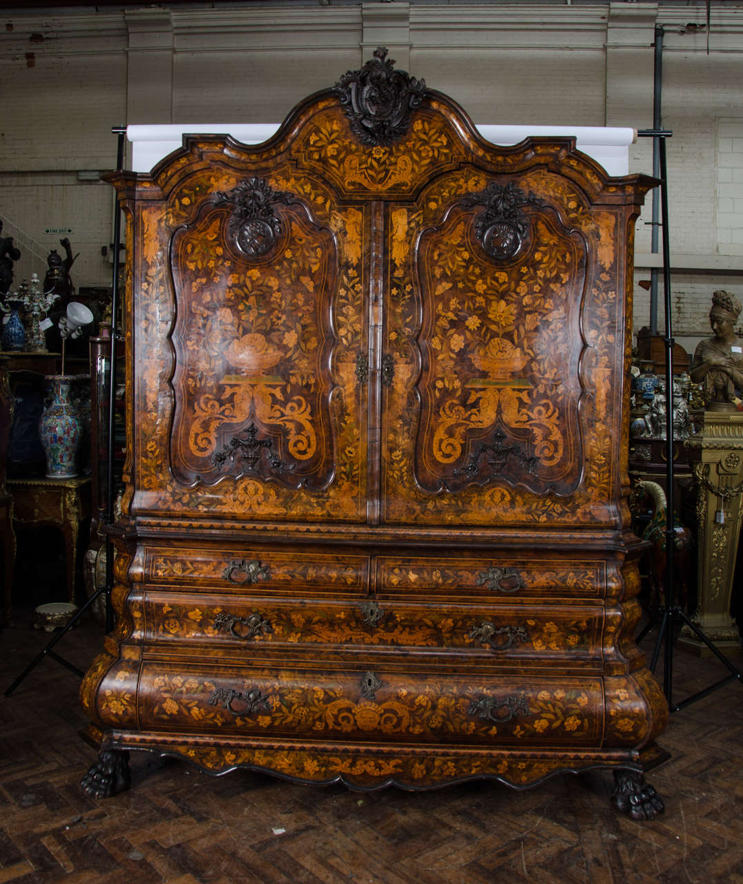 A very imposing 18th century walnut, Dutch marquetry armoire. Having wonderful scrolling foliate inlaid decoration set in recessed panels to the doors. Carved mahogany plaques depicting classical busts. The base being bombe fronted, canted corners