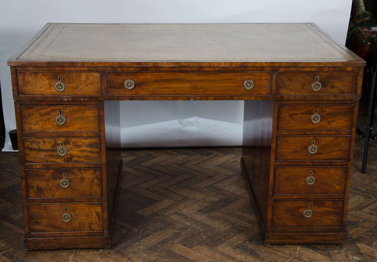 A good quality Georgian period mahogany partners pedestal desk having an inset leather top, 11 drawers to one side, ten to the reverse side, brass ring drop handles and raised on plinth bases.