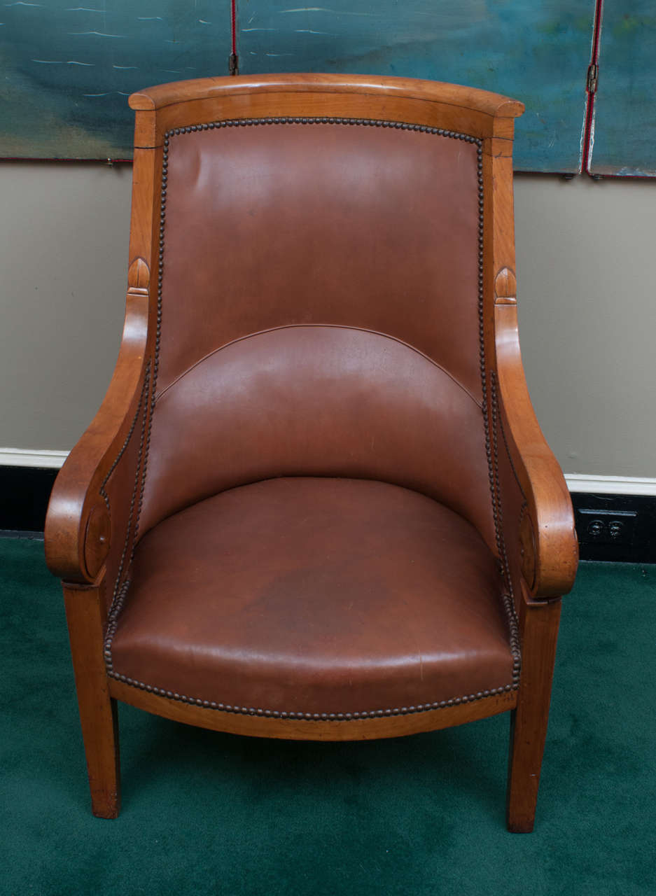 These late Empire bergeres have walnut frames with beautiful patina. French version of a tub chair. Very comfortable, excellent use of nailhead trim.
