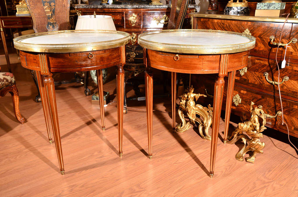 pr of 19th c Louis XVI mahogany and brass mounted Louis XVI bouilette tables with carrera marble tops and pull out slides