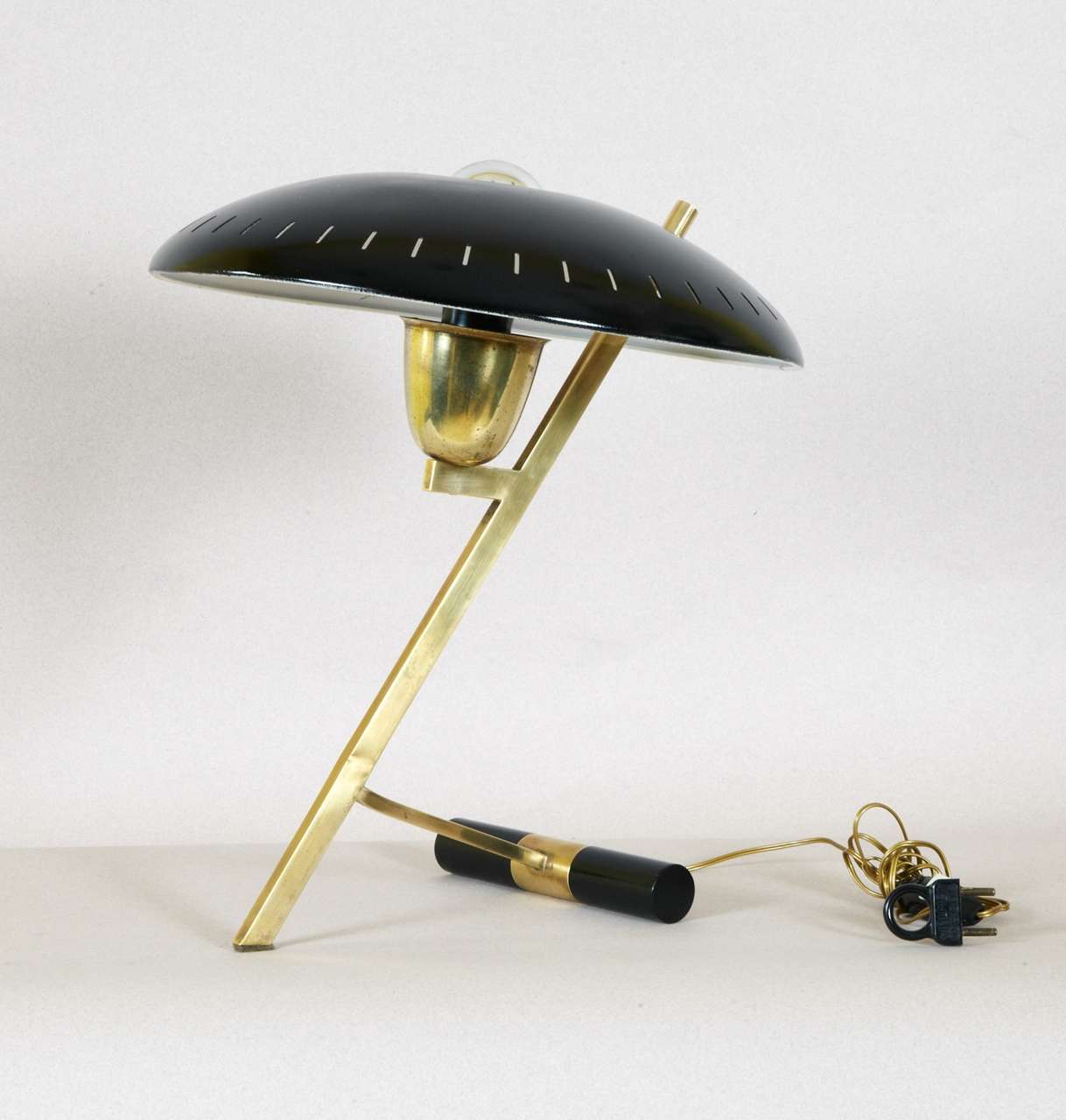 1950s lamp by Louis Kalff for Philips, in gilded brass, foot has ballast; curved shade is perforated. Original plug. Wired for European use. 