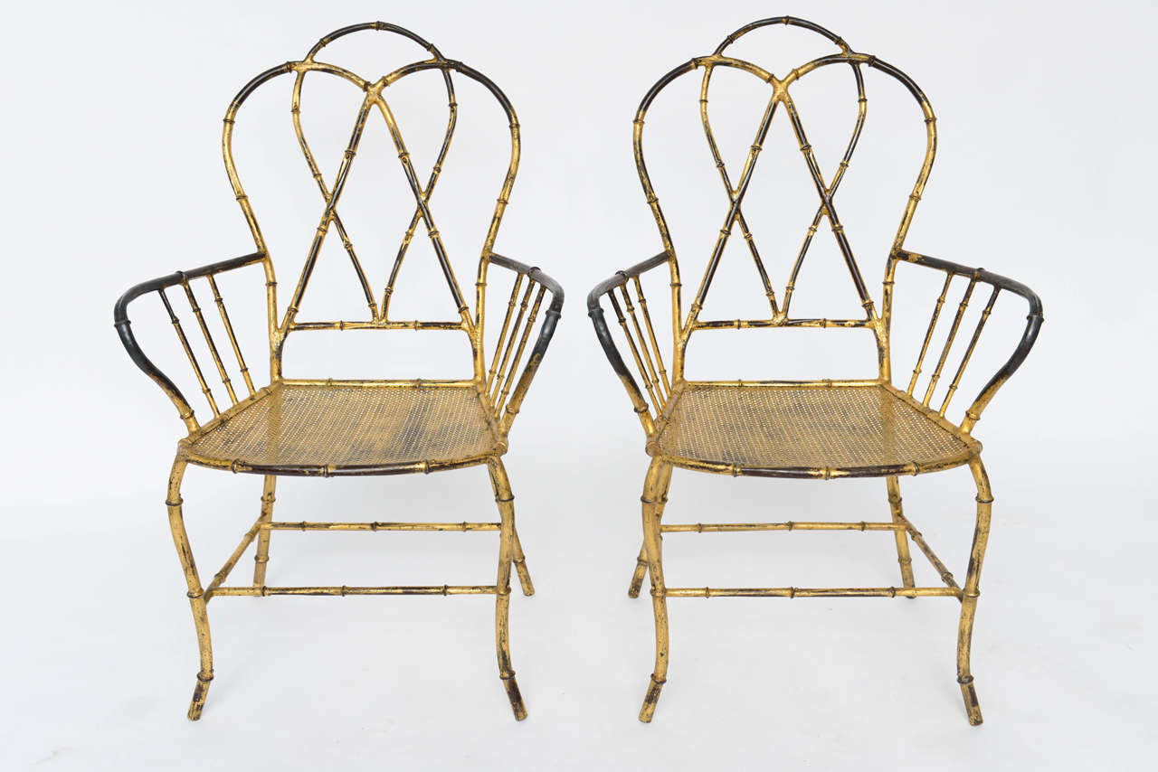 Wonderful pair of 60's Italian faux bamboo armchairs in gold-leafed metal, with picture-perfect, natural wear and patina. 