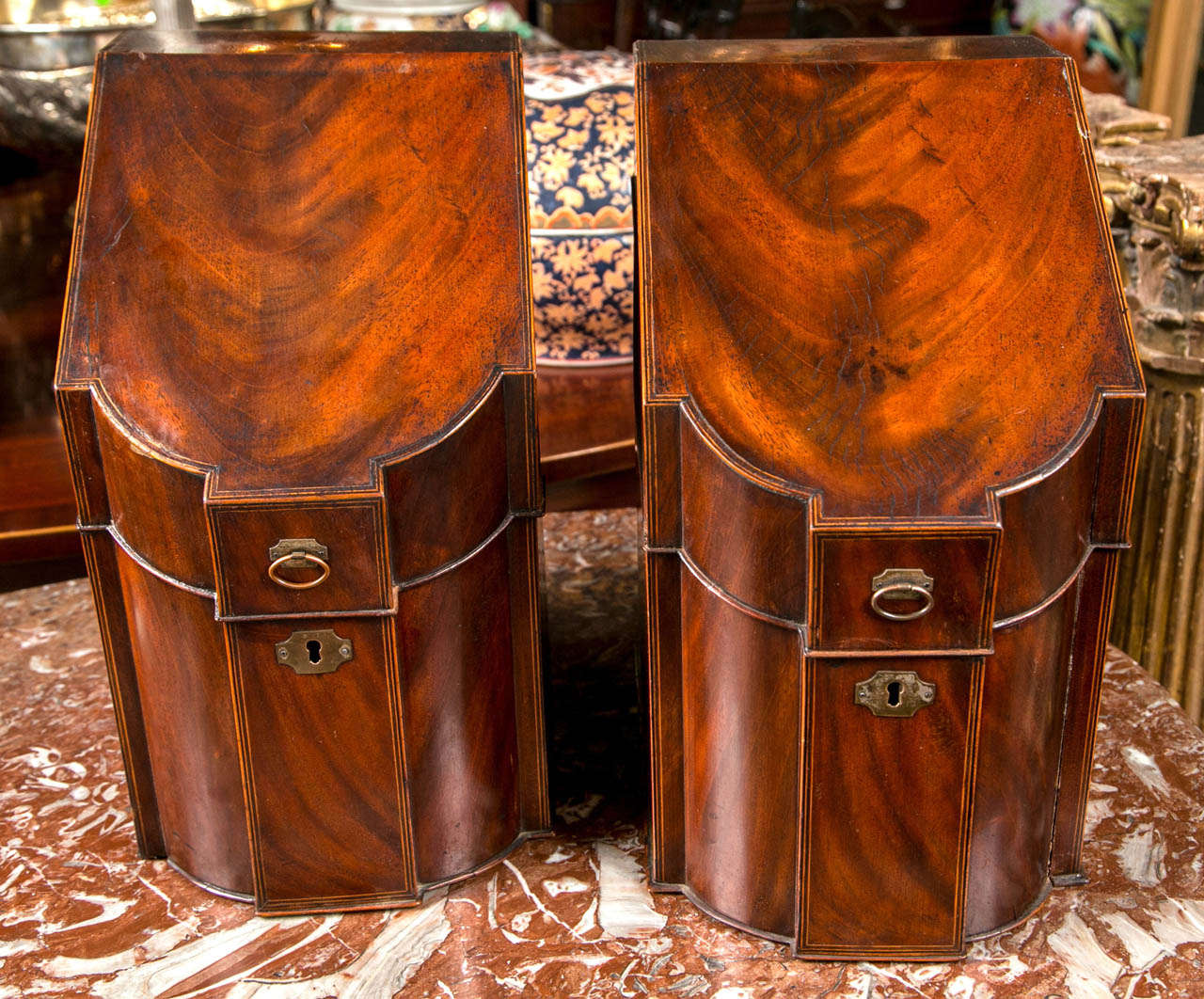 Dating from the late 18th or early 19th. century, pair of boxes were  probably originally knife or cutlery boxes. Now they are for  paper and letters.
Flame mahogany surfaces  with ebony and satinwood stringing, original brass fittings.  The