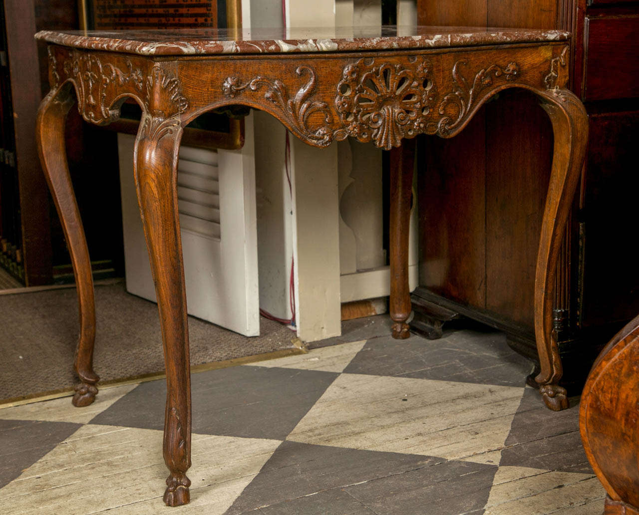 Beautifully carved with shaped and pierced apron, cabriole legs terminating in hoofed feet. The marble  top, a replacement.