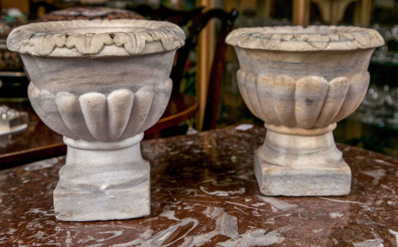 These marble urns, dating from the 18th century  are almost a pair with slight variations in the  rims and heights. We are providing the size of the slightly larger.