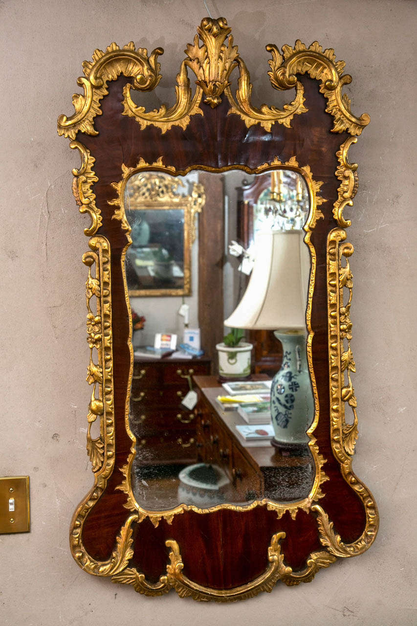 Dieser hübsche Spiegel gehörte höchstwahrscheinlich zu einer Person mit hohem sozialen und wirtschaftlichen Status, da er feine Rokoko-Schnitzereien und ein großes Stück hochgeschätztes (und originales) Glas aufweist. Umgeben von geschnitzten