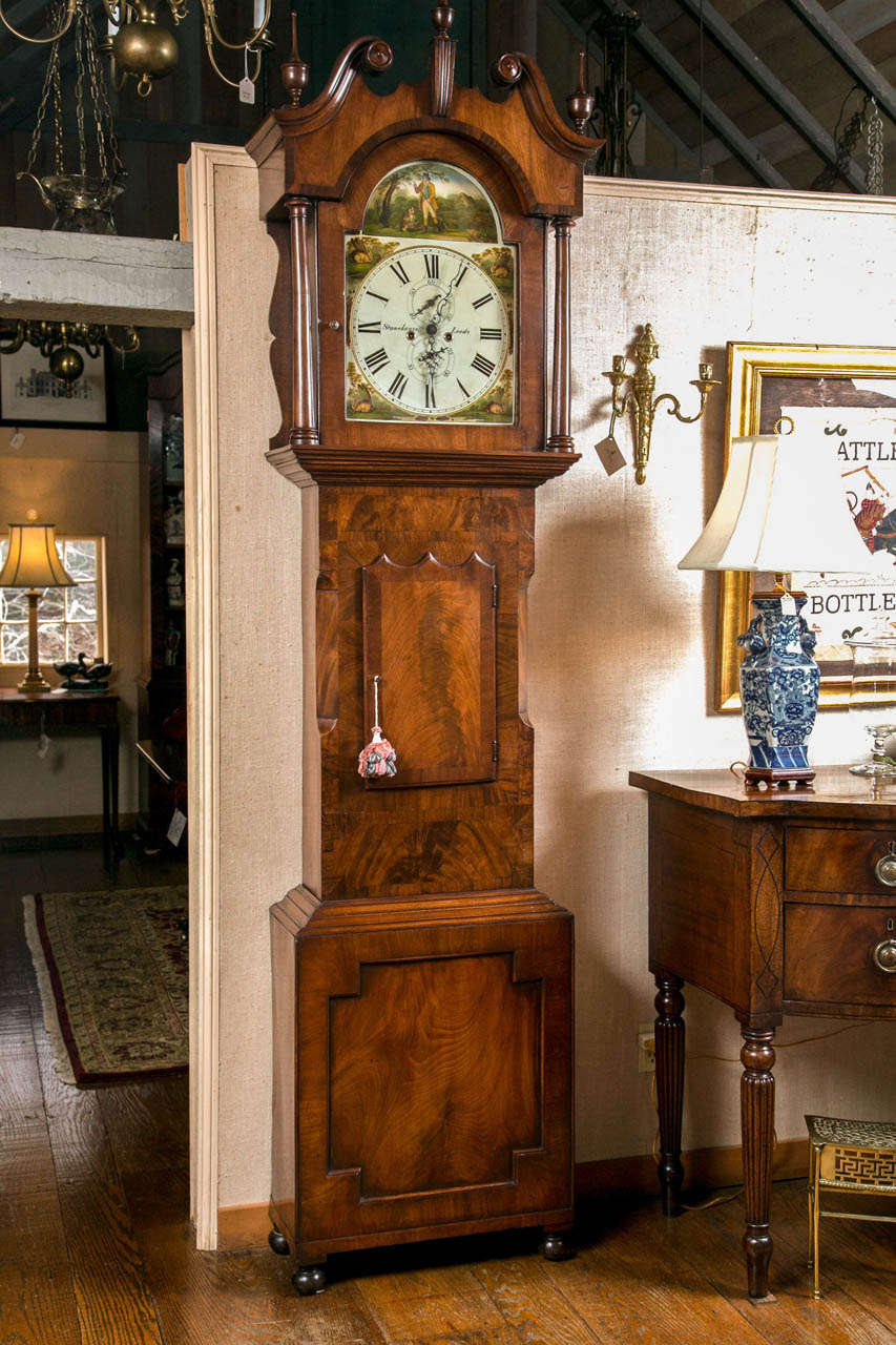 A stunning example of early 19th century craftsmanship, this bold, long case clock has a goose-neck bonnet with finials, keystone and colonettes above a chamfered waist with scalloped door. The base, with its large, shaped recess panel and rests on