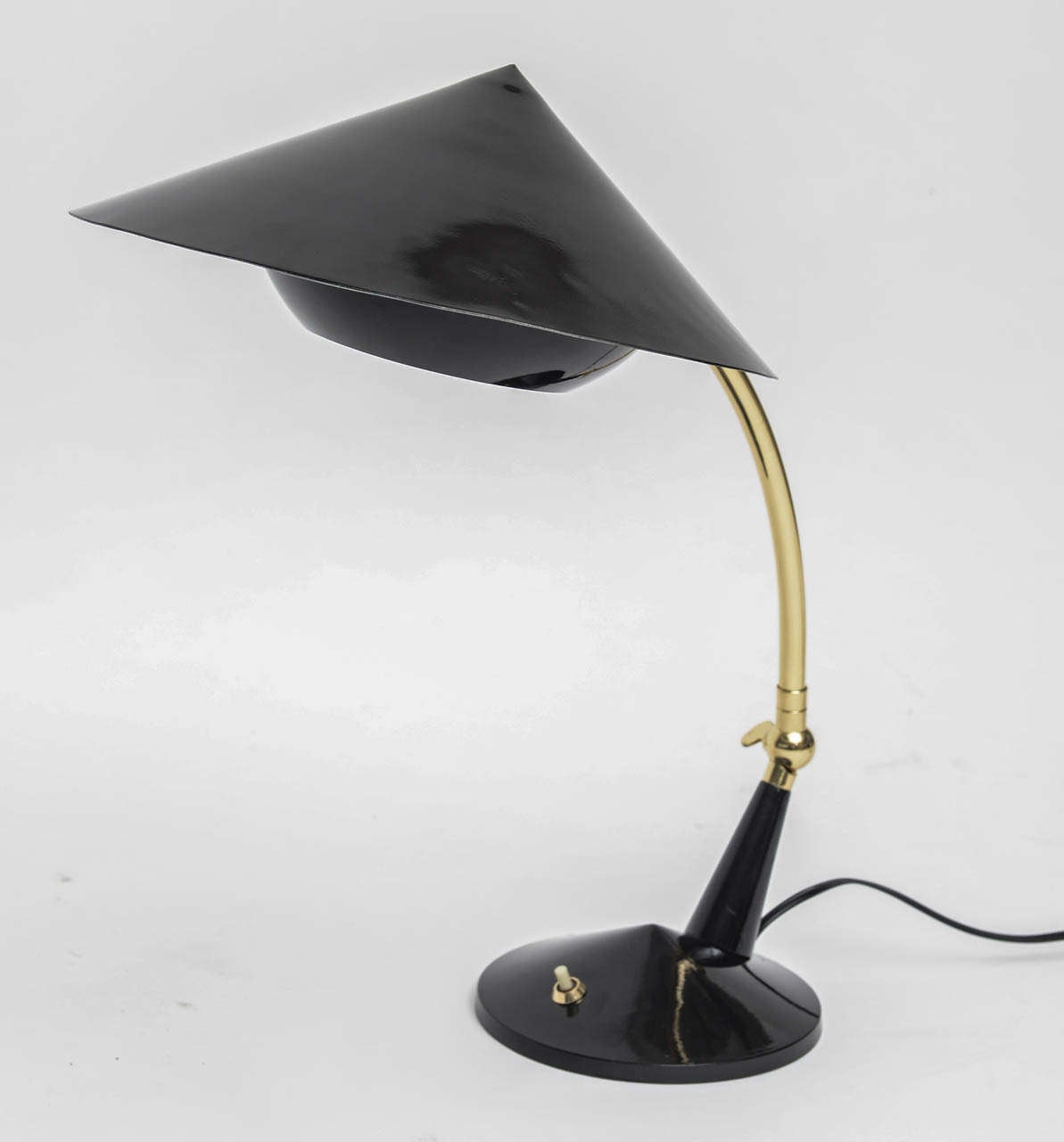 Adjustable 60's Italian desk lamp has reticulated, polished brass arm, black metal shade and diffuser, and black plastic base. Re-wired.