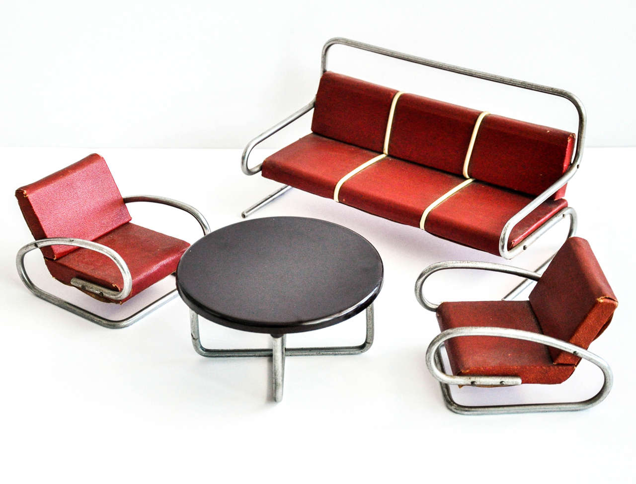 A four-piece set of miniature tubular furniture attributed to the Czech designer Jindrich Halabala (1903-1973). Halabala was a modernist Czech furniture designer who created functional, modular and affordable furniture that is prized today by