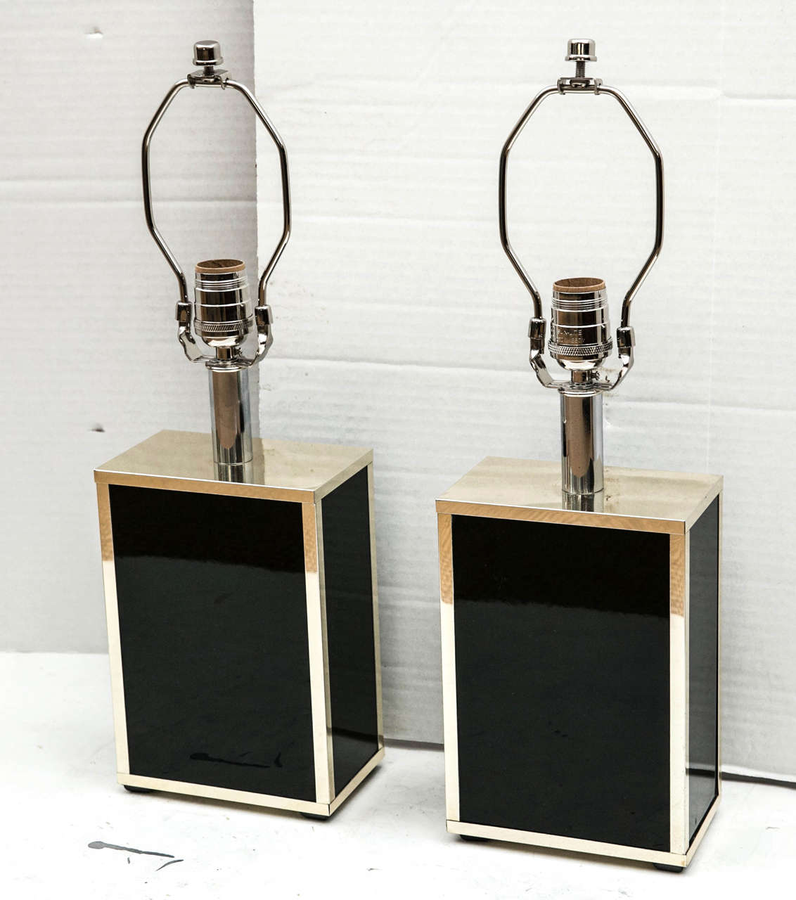 A pair of chrome framed rectangular box form lamps with panels of black glass on all sides. All new wiring for the US.