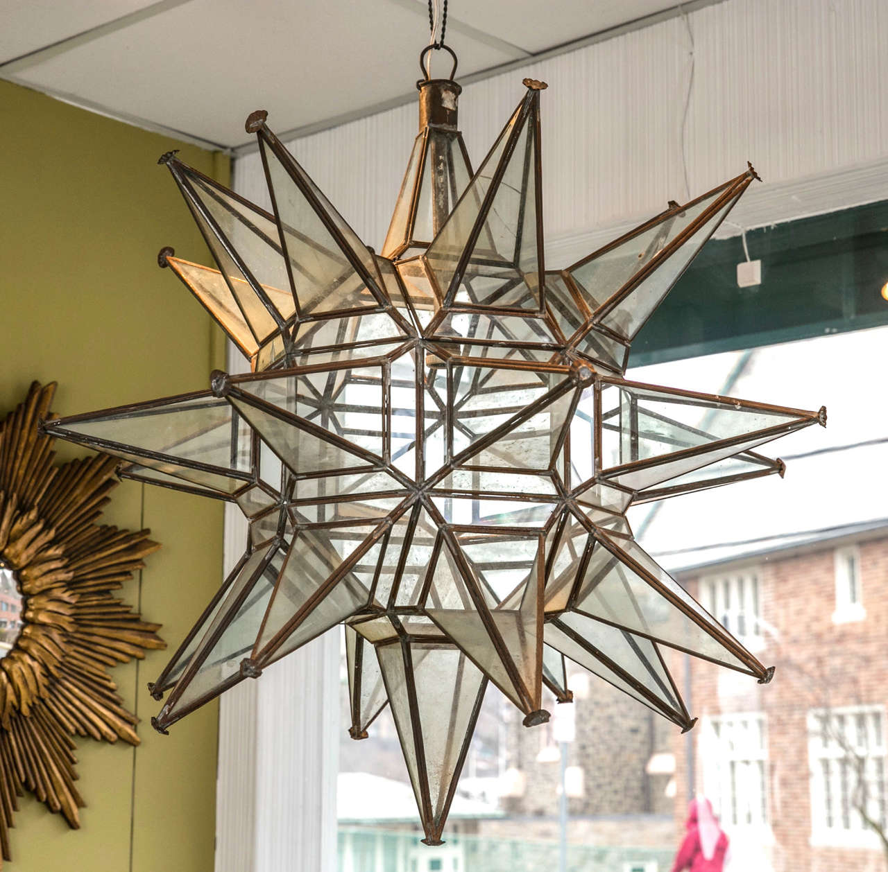 Unique brass and glass star-shaped lantern fixture.