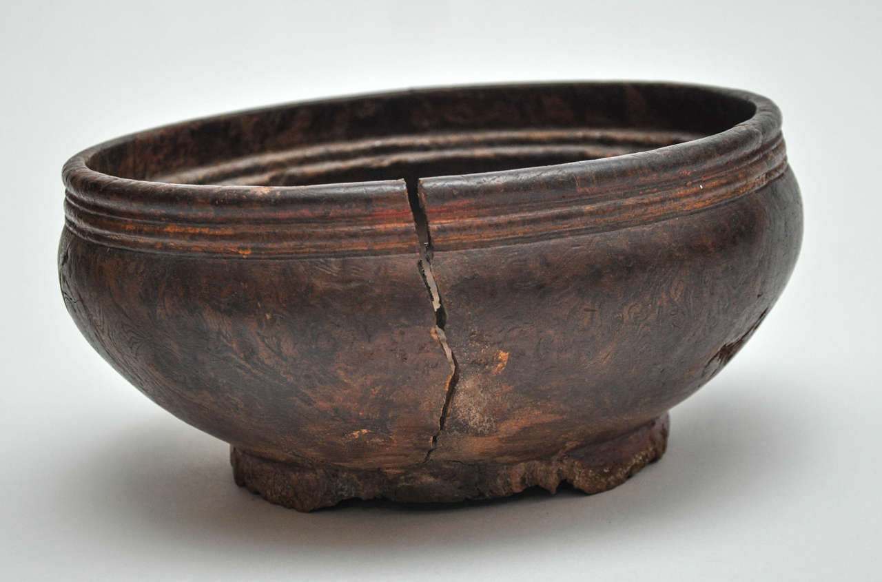 Early 19th century Naga bowl. These beautiful primitive bowls were used in kitchens for various food oriented activities including storing and cooking. 
This example shows typical subtle carvings which verify its origin. 
The details have been