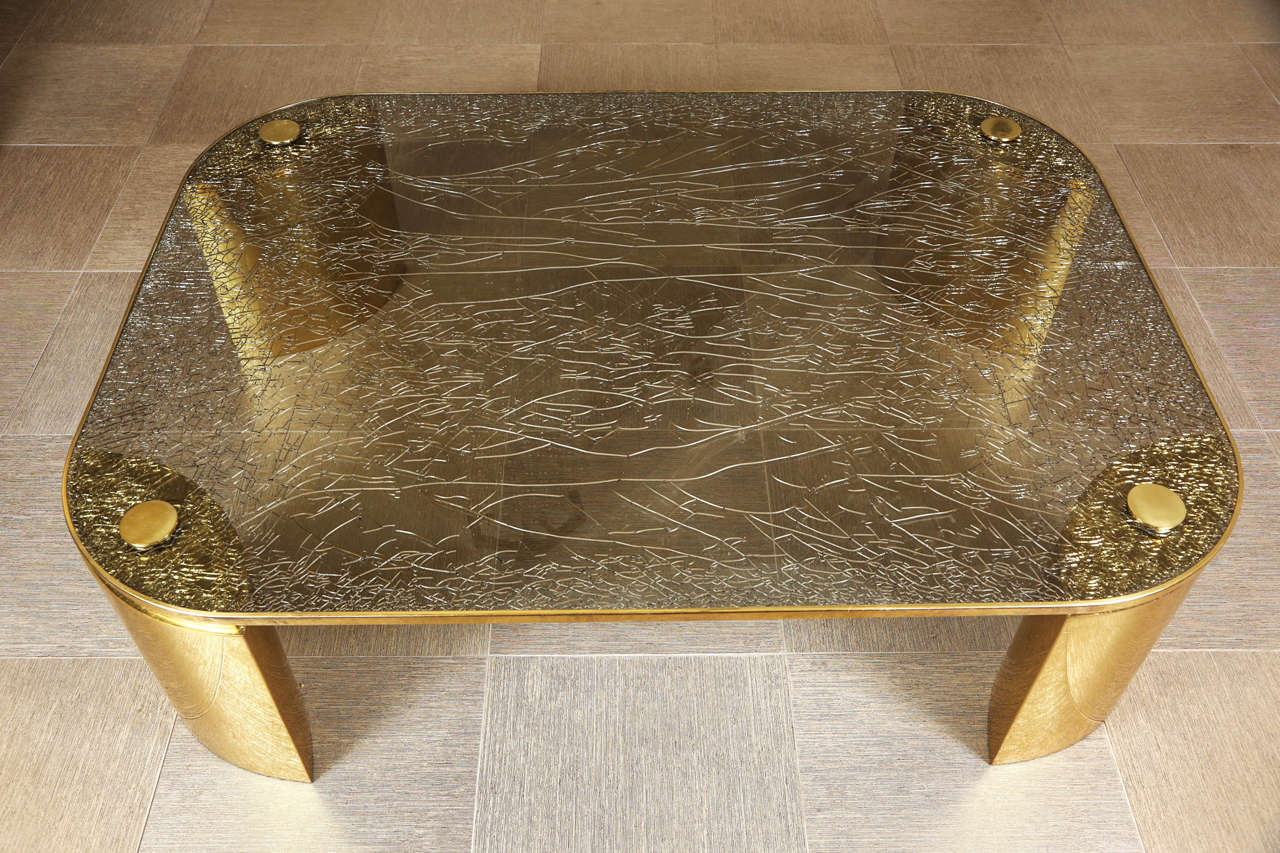 Fantastic coffee table by Steve Chase. 
The large polished brass legs support a stunning example of 
Steve Chase's crackle glass, which is edged in brass. 
Four large screws with solid brass tops secure the top to the base, which has a beautiful