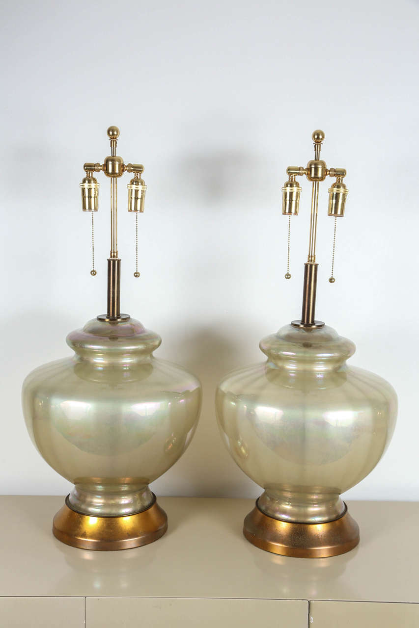 Large pair of glass lamps which have a reverse painted pearlized finish.
The lamps are mounted on gilt colored metal bases, having a wonderful patina and are newly rewired with brass double clusters.