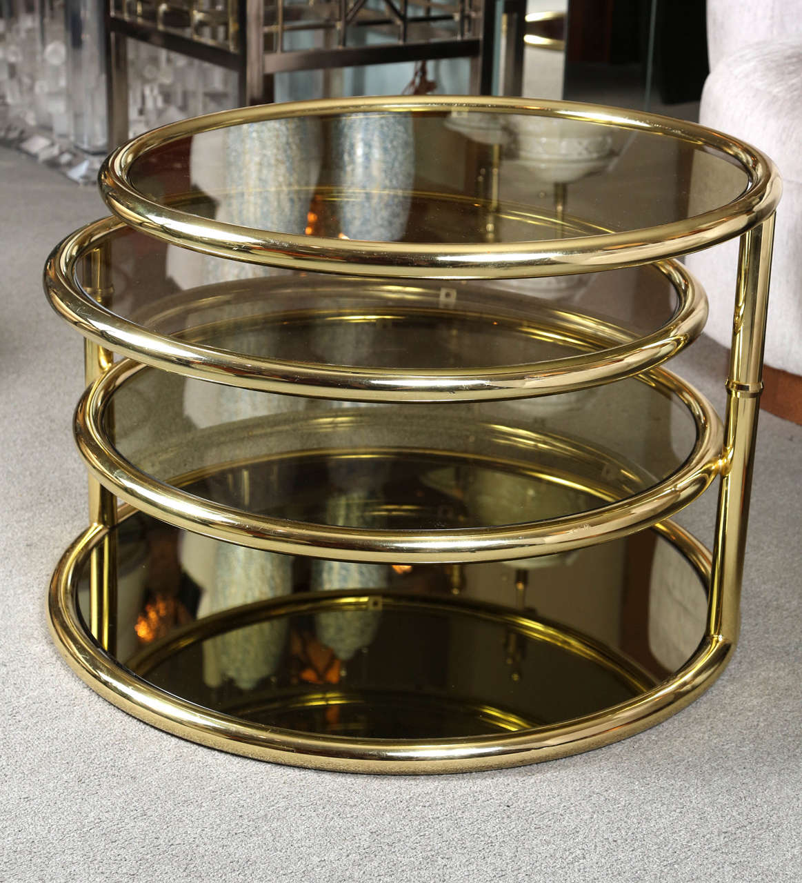 Elegant cocktail table with four different levels in a polished brass finish and
smoked glass.