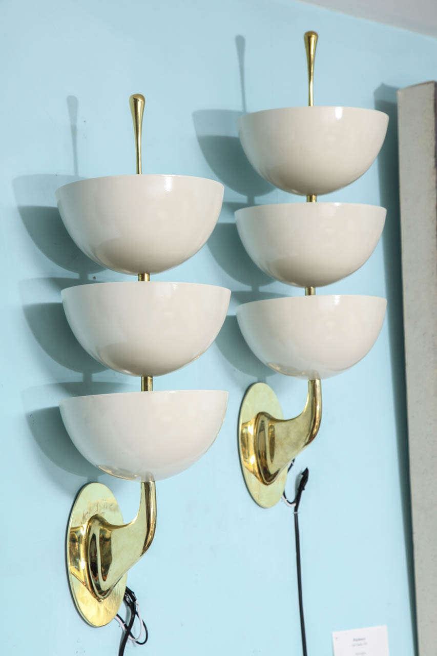 Classic Stilnovo forms comprised of painted metal cups & polished brass stylized supports. Each sconce has 9 candelabra sockets concealed inside of the cups, making these a great source of light.  Oval backplates created new and not part of the