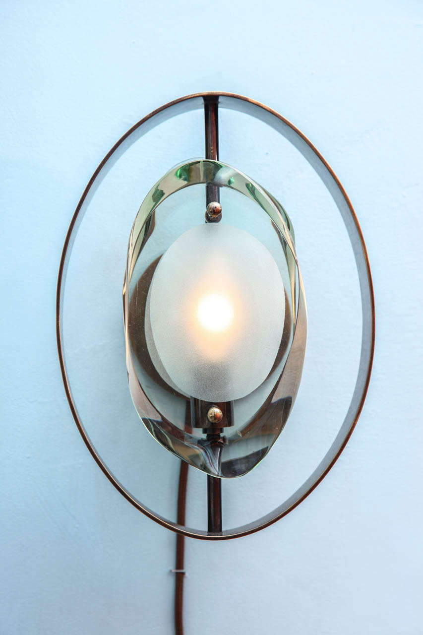 Sculpted glass forms with partially frosted centers. Brass mounts with original patina. Newly-made wall plates. Each sconce has one candelabra socket.