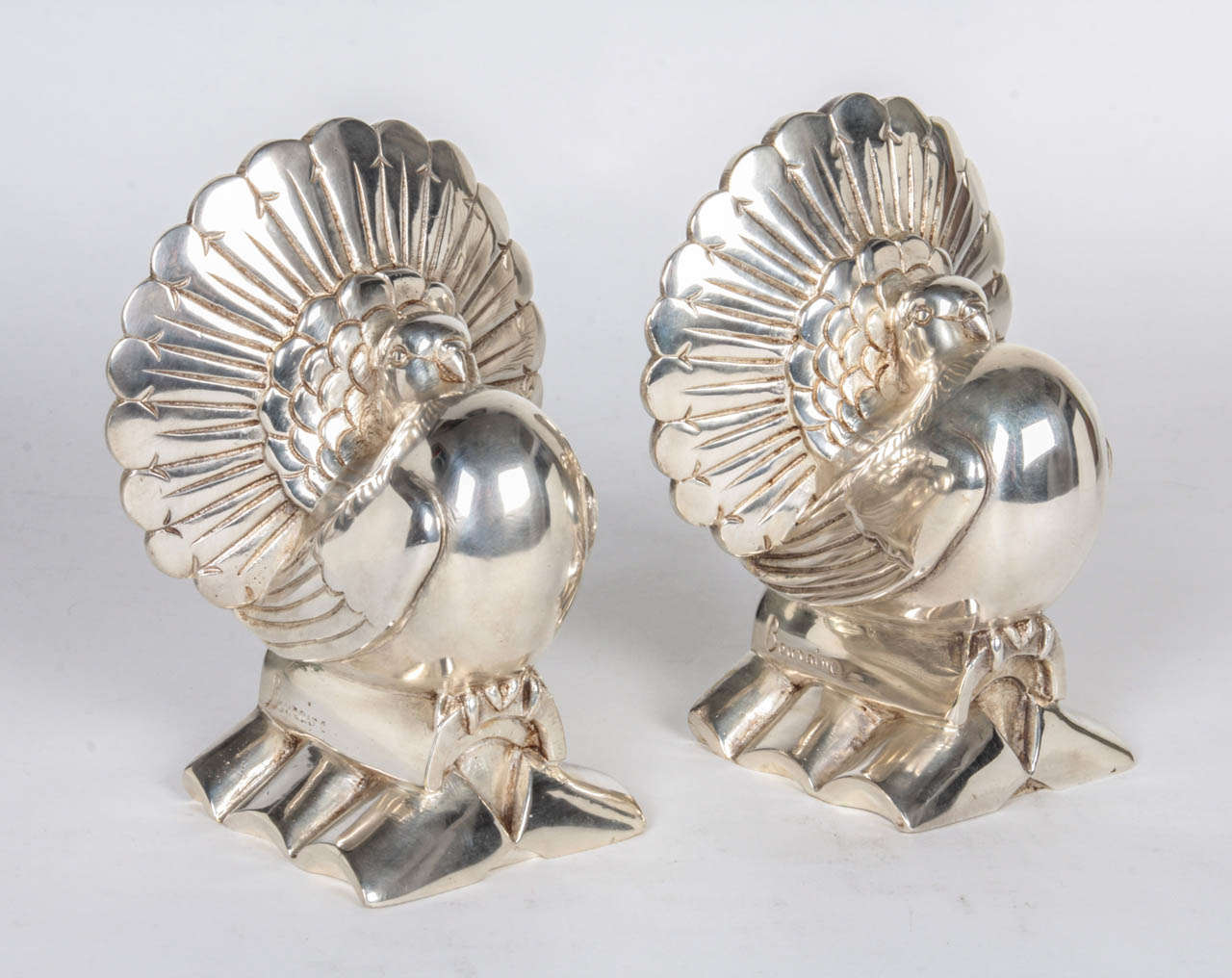 Marcel Bouraine (active 1925-1930) France.

Pair of Art Deco “Dove” sculptural bookends, circa 1930.

Silvered bronze (sand cast technique) in the form of doves with openly displayed and fan shaped tail feathers perched on roof pan