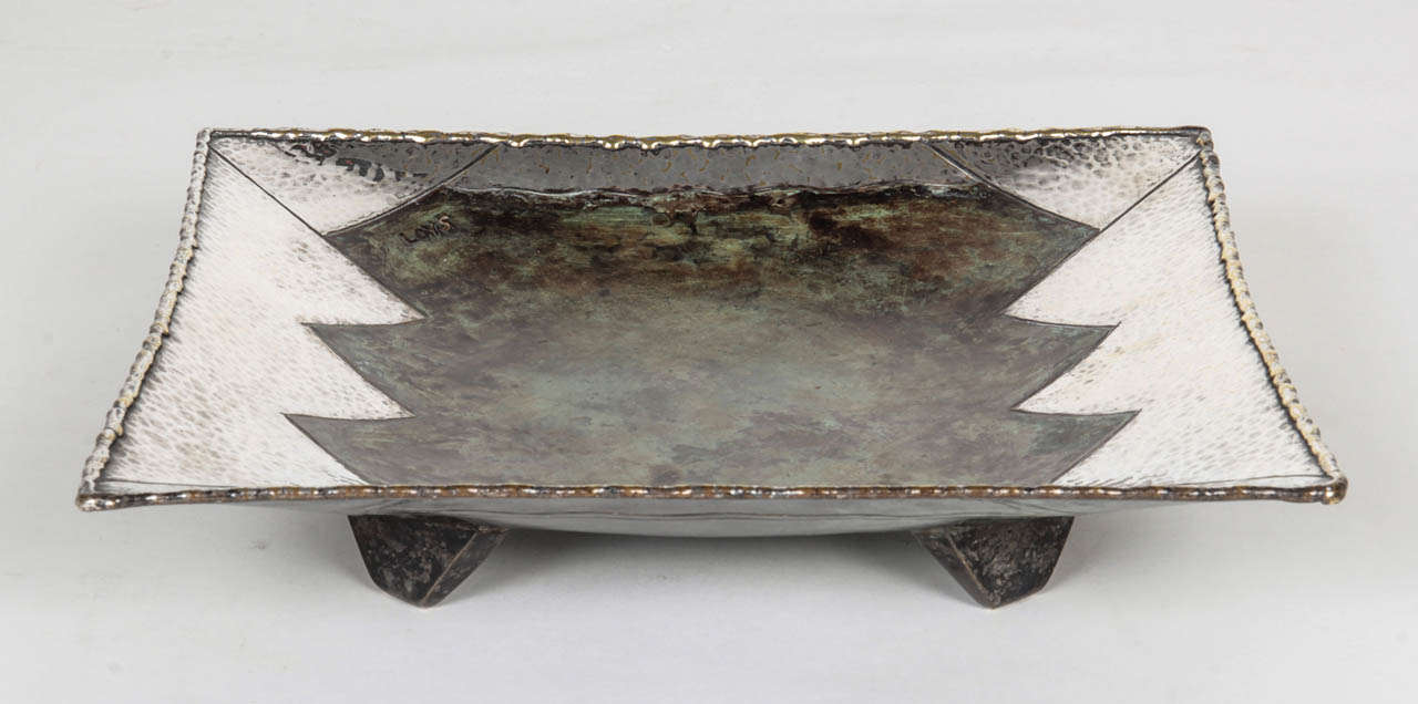 LOYS LUCHA   Paris

Dinanderie “Zig Zag” Square footed dish c. 1925

Handwrought and hand hammered copper, brass and white metal with silver plated zig zag details and a rich, verdigris patina 

Marks:   LOYS (incised on front), LOYS PARIS