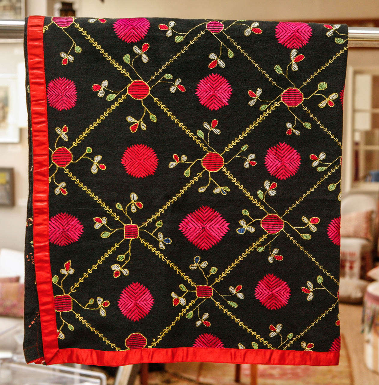 Hand embroidered shawl from the Swat Valley, Hindu Kush. Black background with bright pink silk  details and red,  light green, yellow, and white cotton embroidery. Red satin ribbon edging all around.  Dimensions: 44