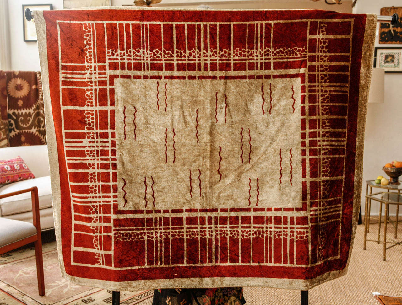 Silk velvet throw with art deco design in creme with red details and red border.
