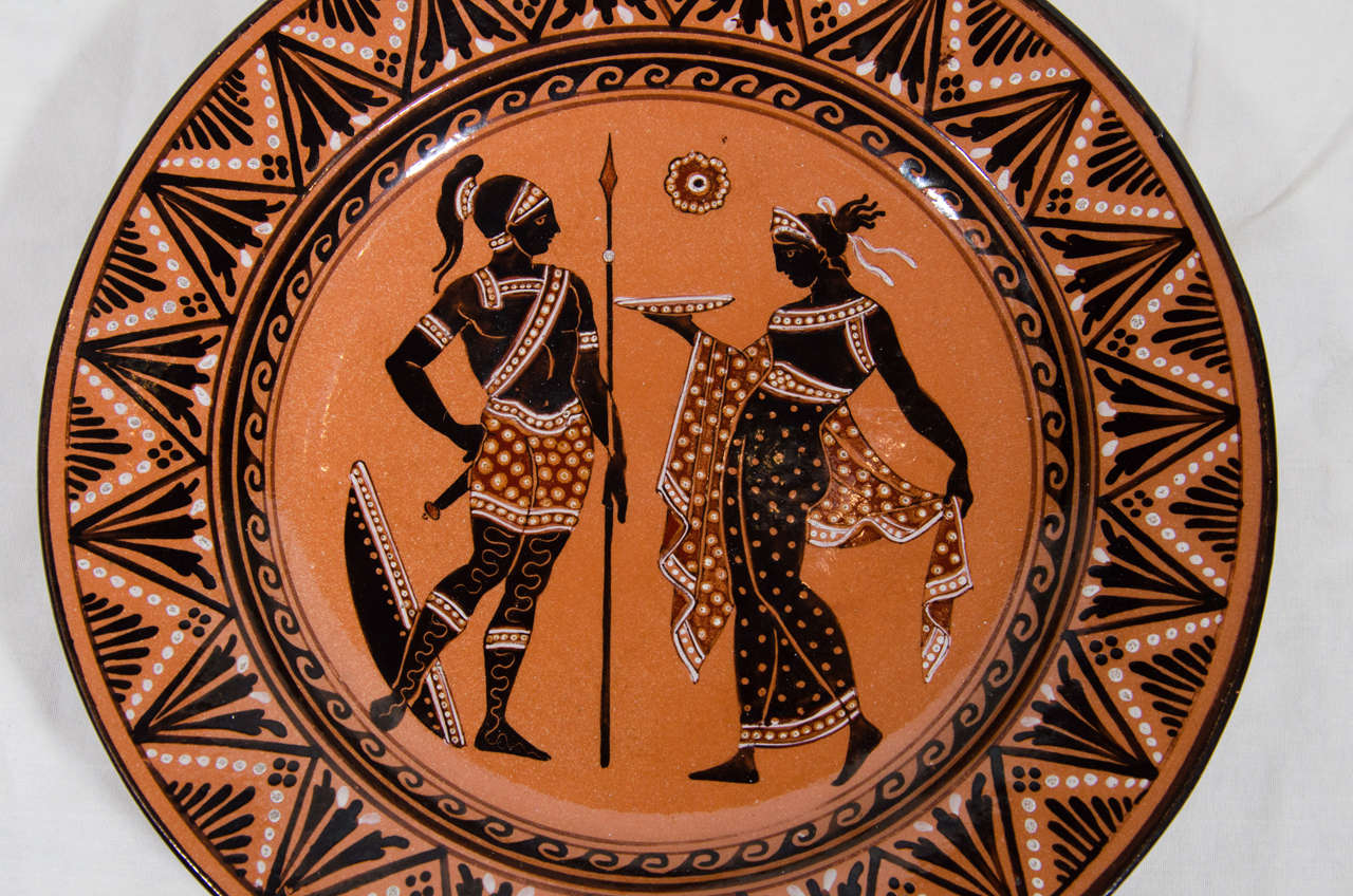 A Giustiniani redware Greek Revival dish decorated in the Etruscan style after the antique. With classical figures painted in black and red on a terracotta ground all within a geometric border.
Made in the factory of the Giustiniani Family which