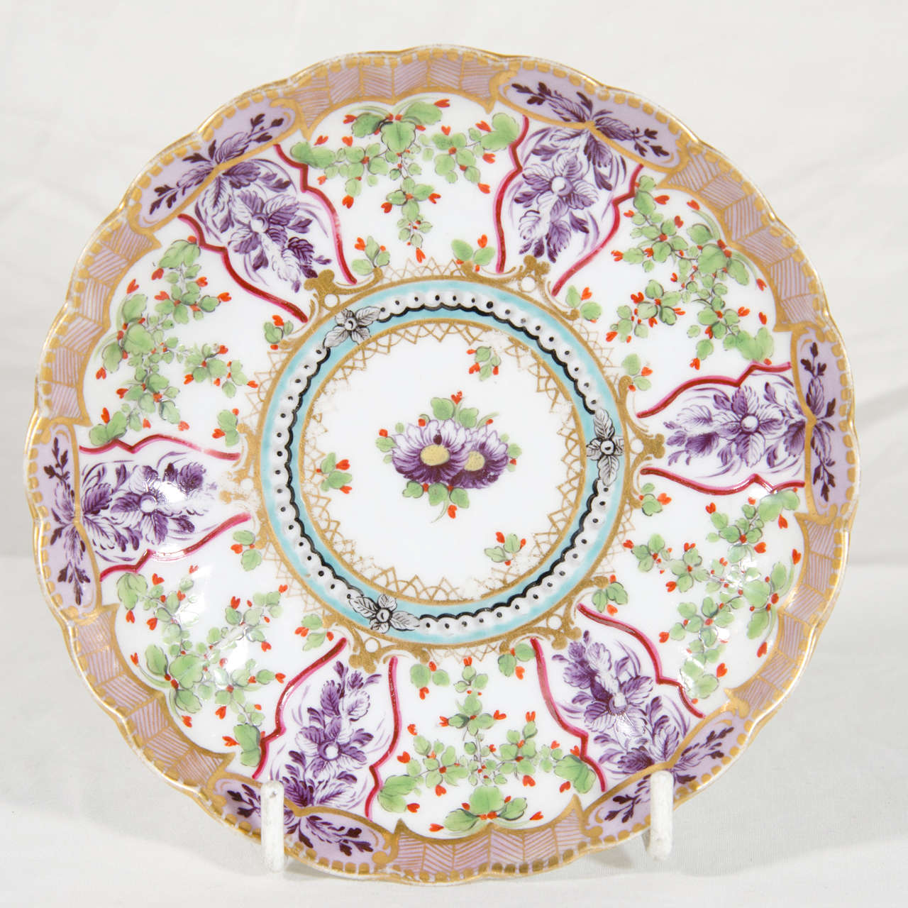 A very fine Flight and Barr Worcester tea cup and saucer of fluted form, from the lilac version of the Holly Berry Service in the Sevres style. Painted with a flower spray in the center surrounded by a turquoise circlet of faux pearls all within a