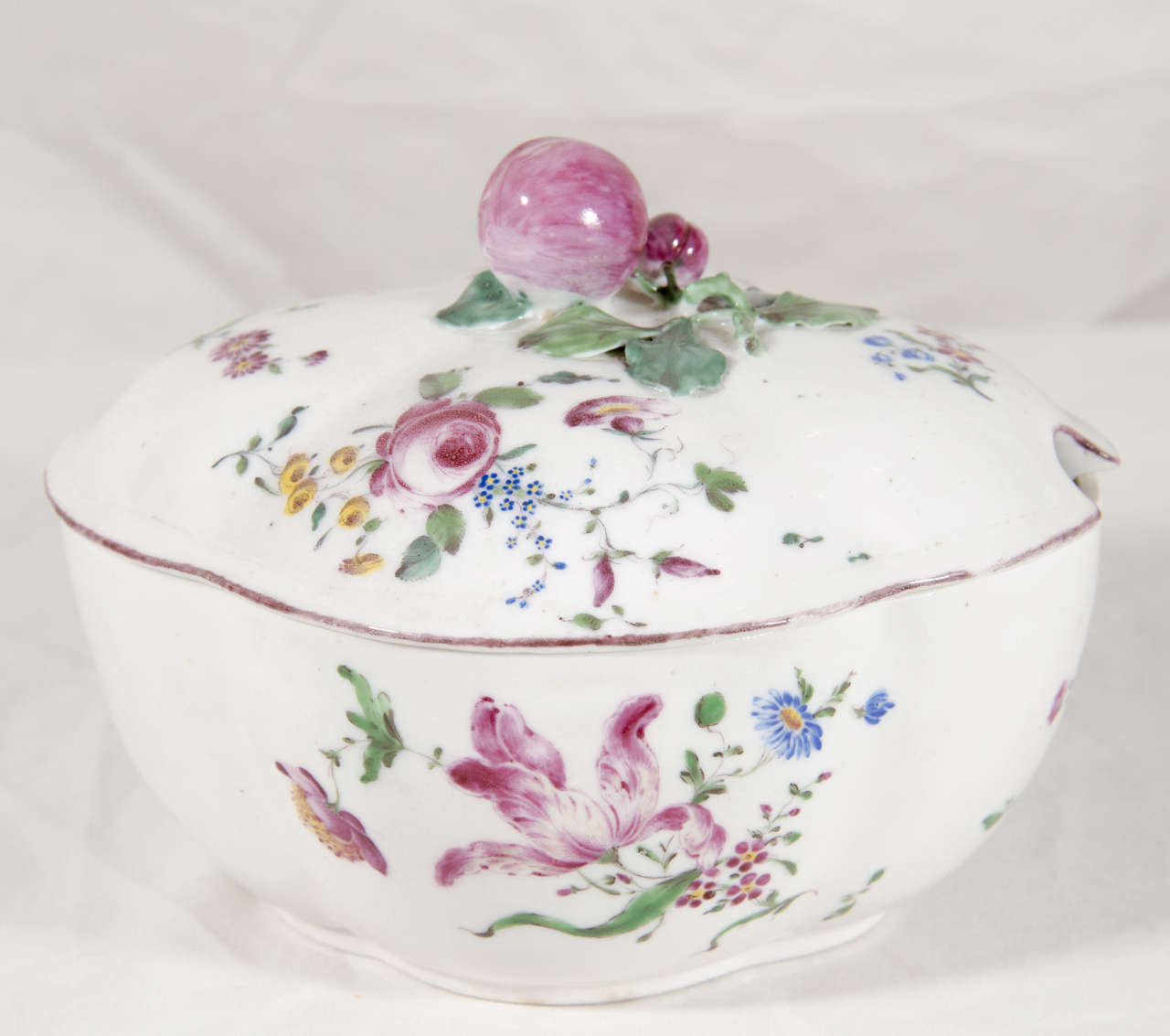 The Mennecy porcelain manufactory produced fine quality soft-paste porcelain wares decorated with flowers richly painted in enamel colors, among them the distinctive purple-rose hue seen on this tureen. The factory was active from 1735 until