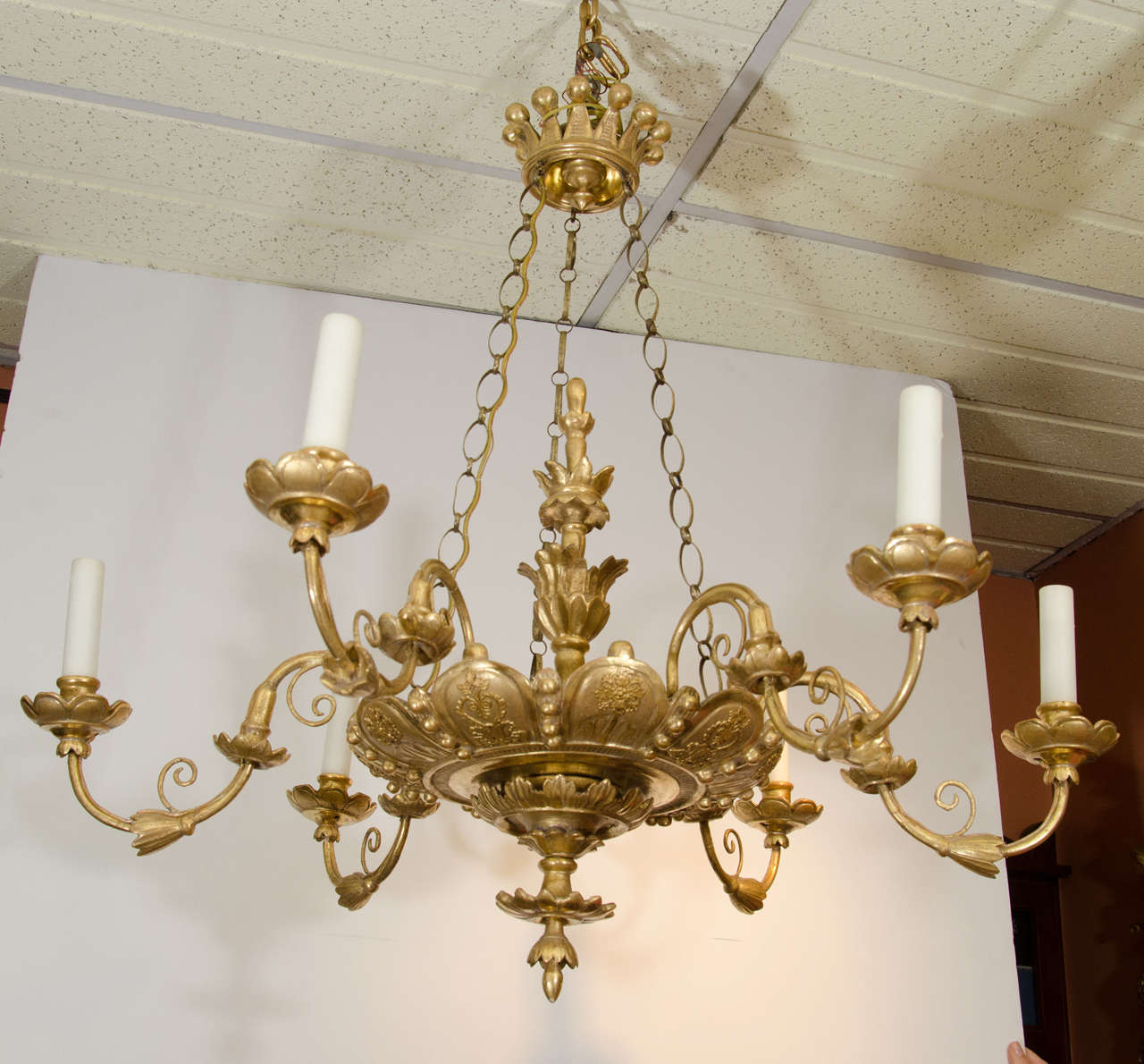 Fine Italian six-light giltwood chandelier with S-scroll arms and delicate raised foliate motifs to the scallop carved dish, chased chains suspended from gilt crown form corona.
