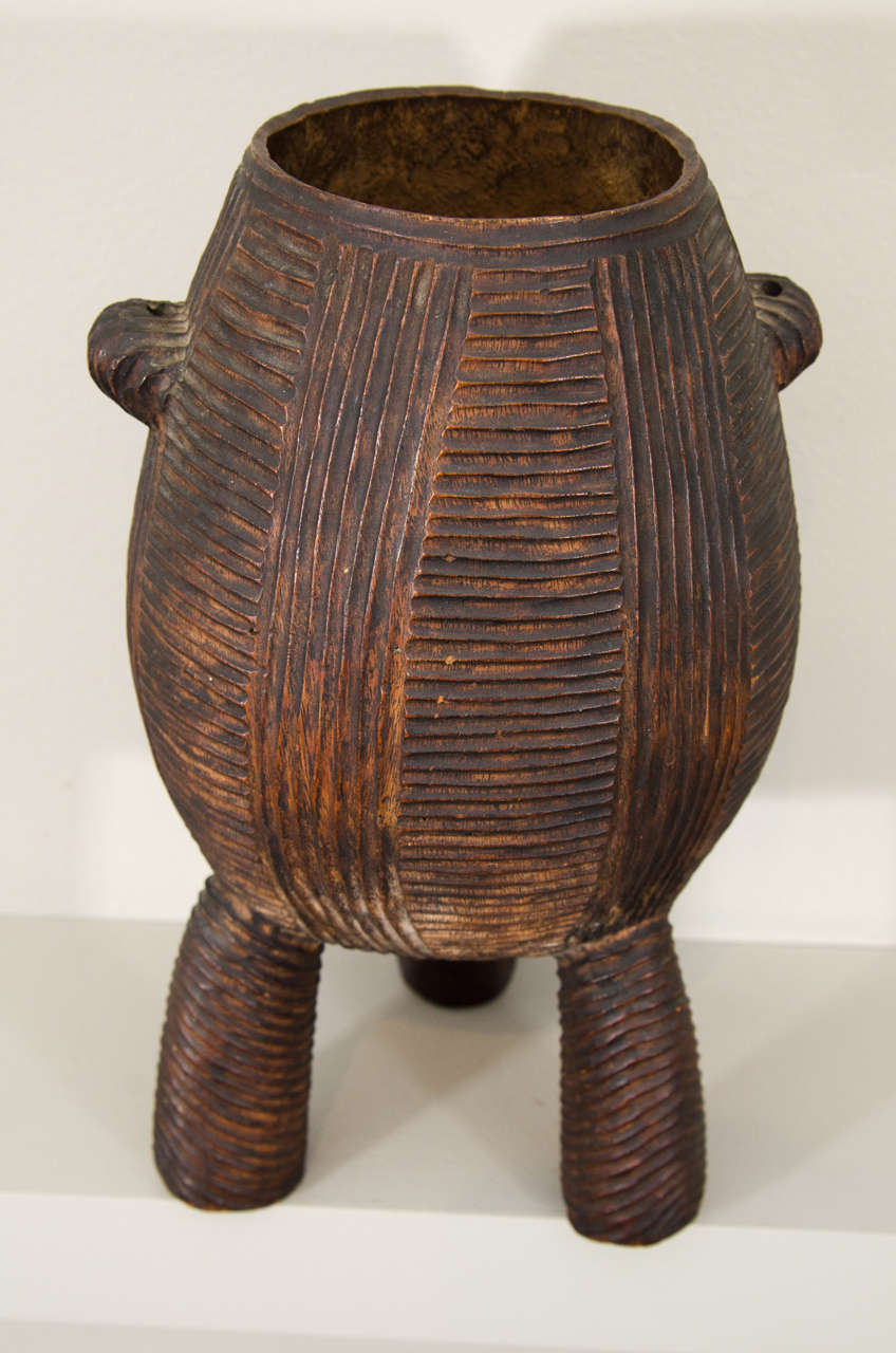 This early Zulu vessel is part of a small group of highly decorative vessels, made in the mid-to late nineteenth century, that are widely admired but not well understood. Also tied to this group are several neckrests that have similarly shaped legs