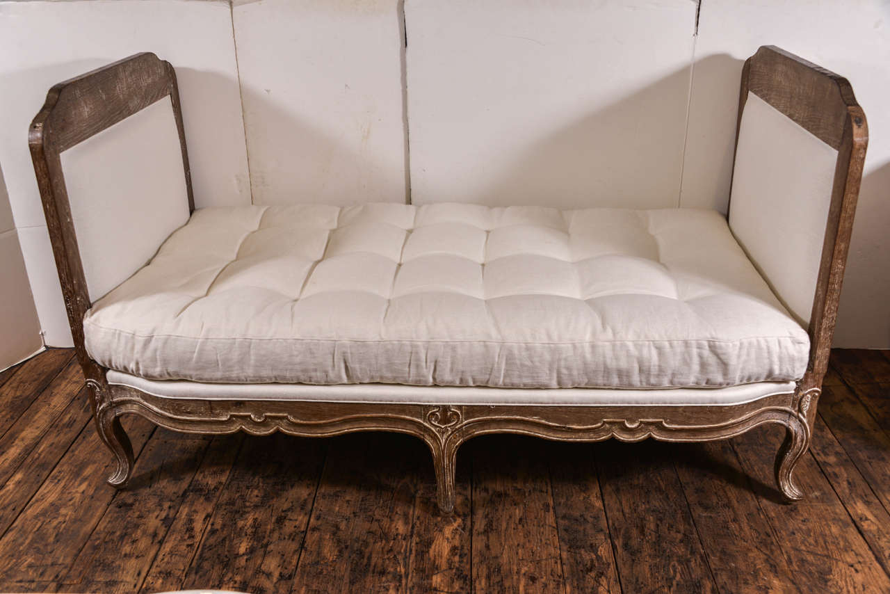 Handsome and large scaled French daybed in walnut. Traces of white paint remain, late 18th-early 19th century. Down cushion recently done. Finished on the back as well so can float in the room. In very good condition.
