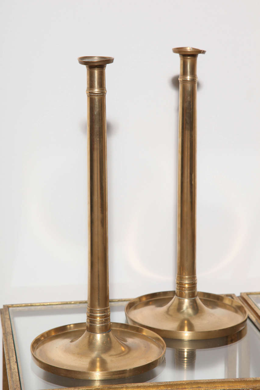 Pair of brass candleholders with delicate detail at top and base.