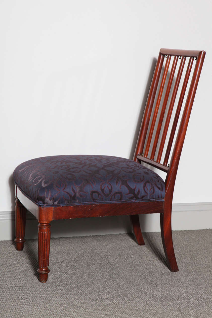 Mahogany chair with spindle back and bronze knobs that were originally used to attach a pillow.  Recently reupholstered.